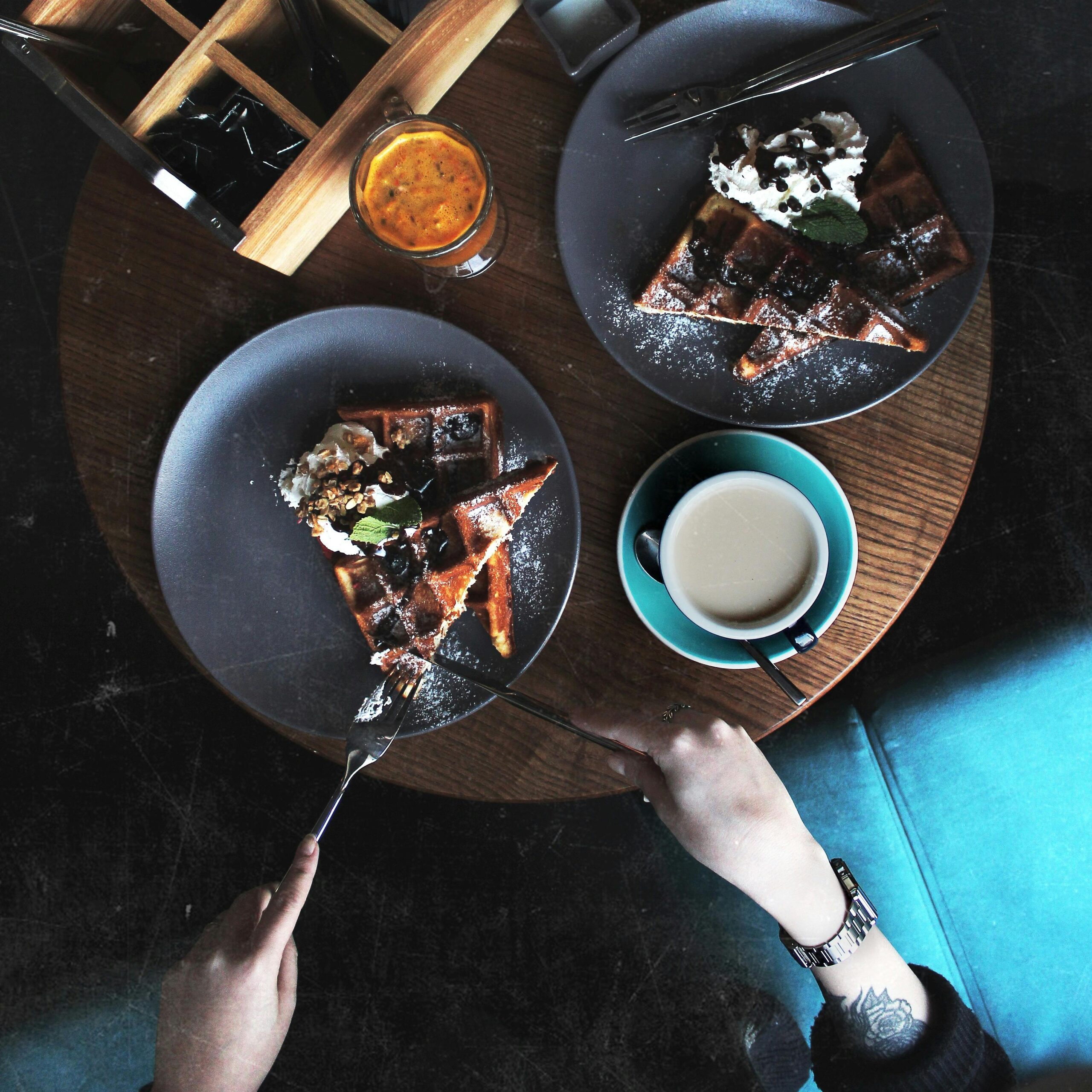 Overhead view of a cozy breakfast spread with waffles, coffee, and juice in a café setting. Perfect for morning inspirations.