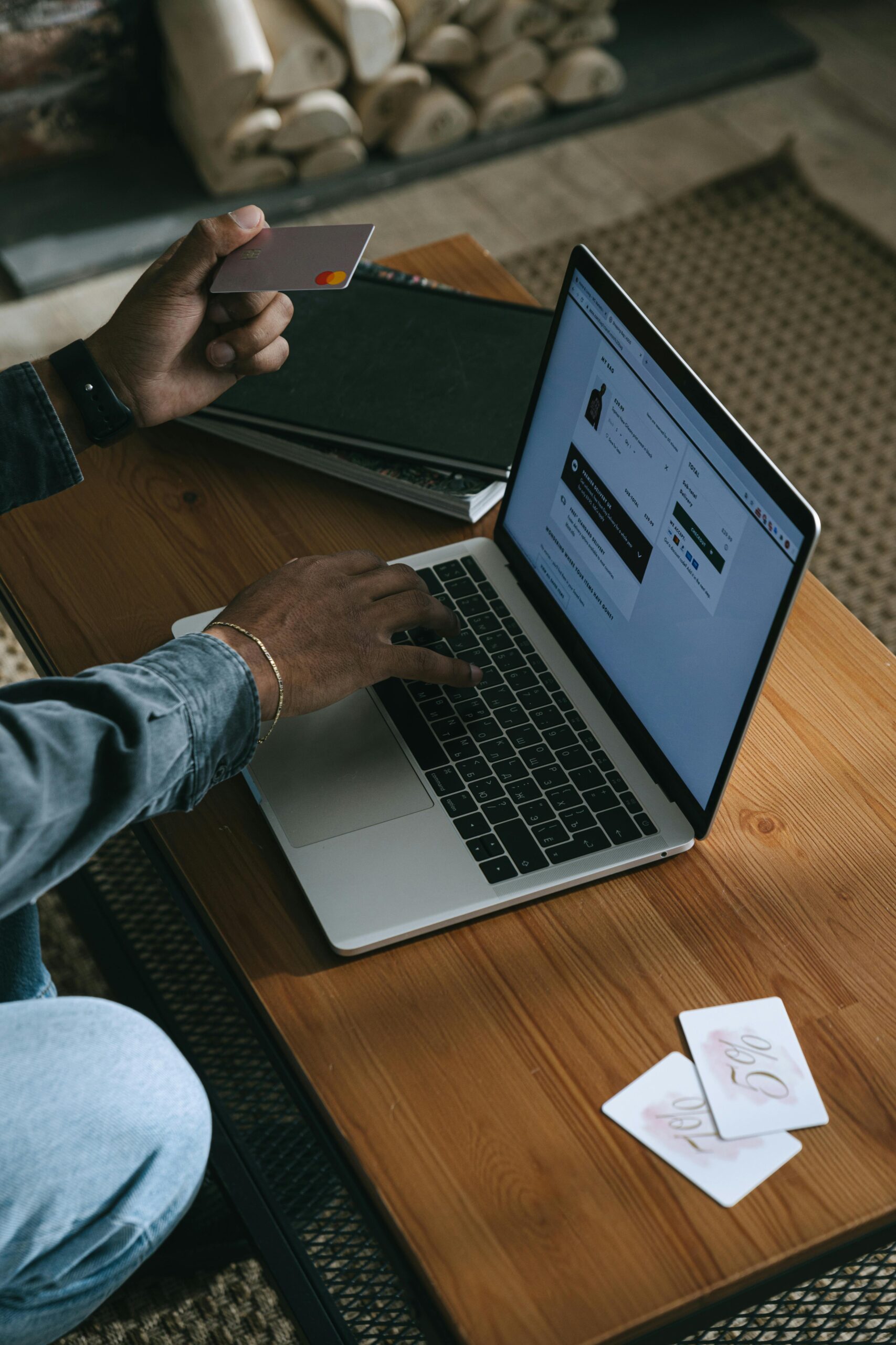 Person using a laptop for online shopping with a credit card in hand.