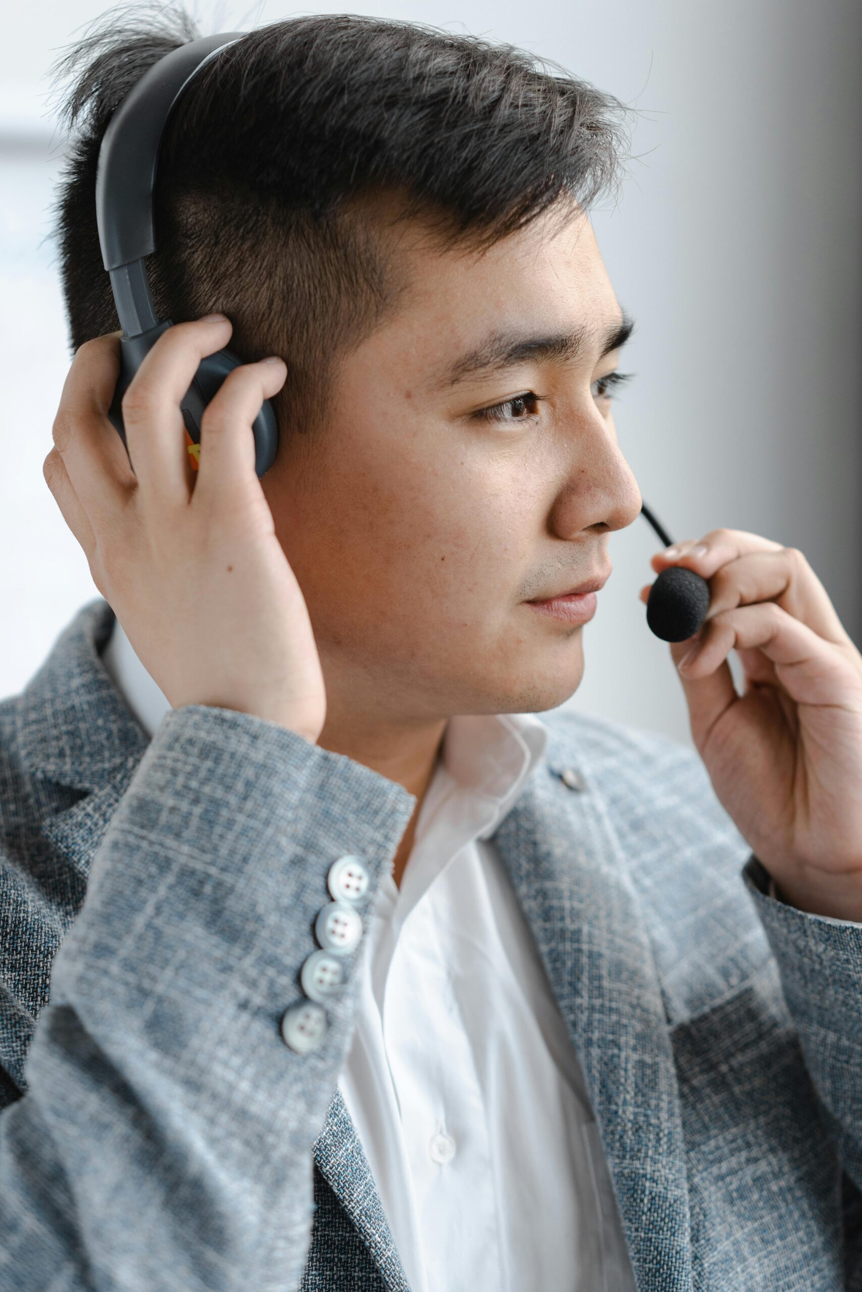 Asian call center agent with a headset focused on providing excellent customer support.