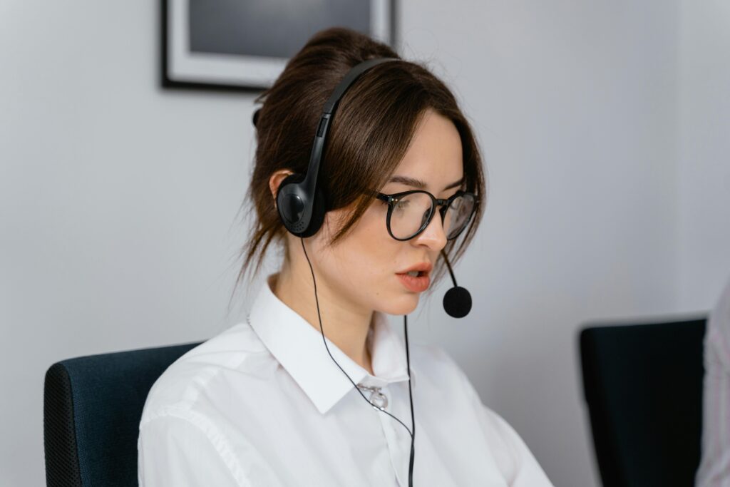 Focused woman working in a call center with a headset, providing customer support and communication services.