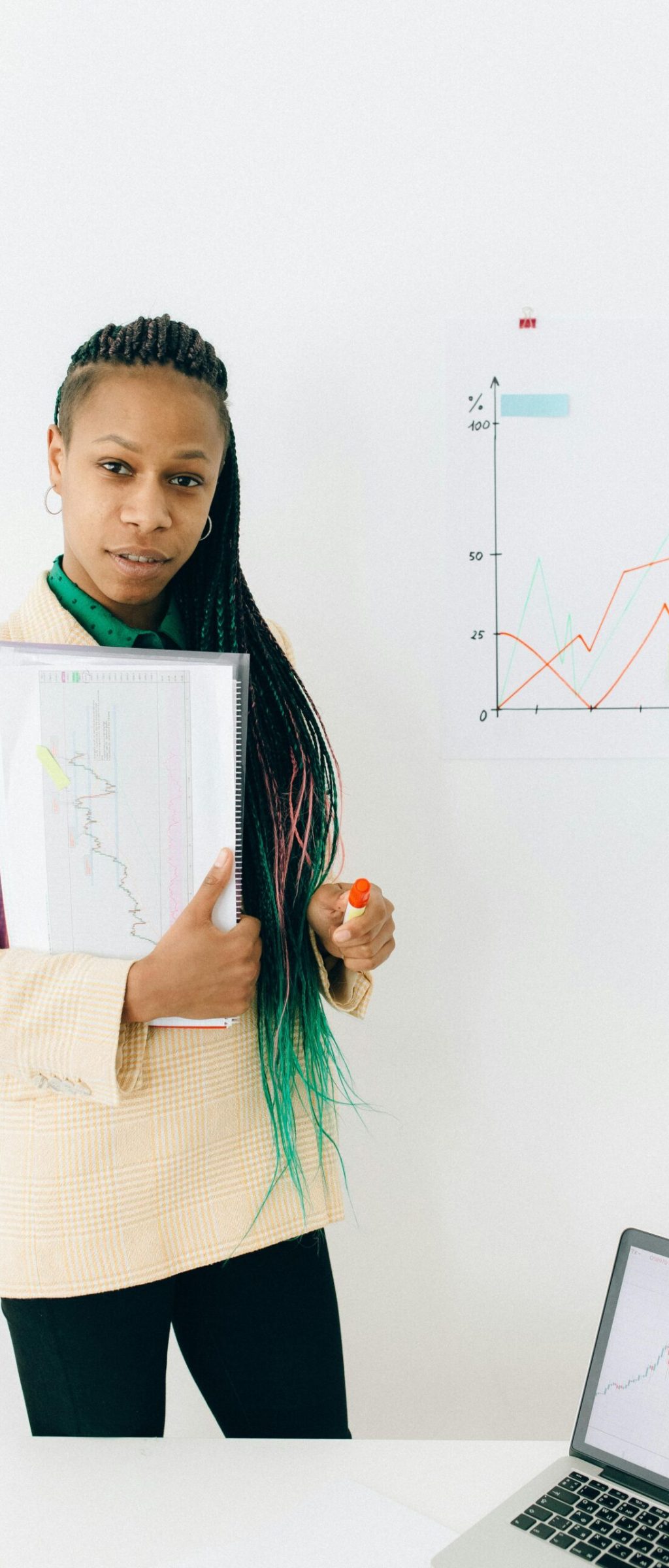 Confident analyst presenting financial data and growth charts in a modern office setting.